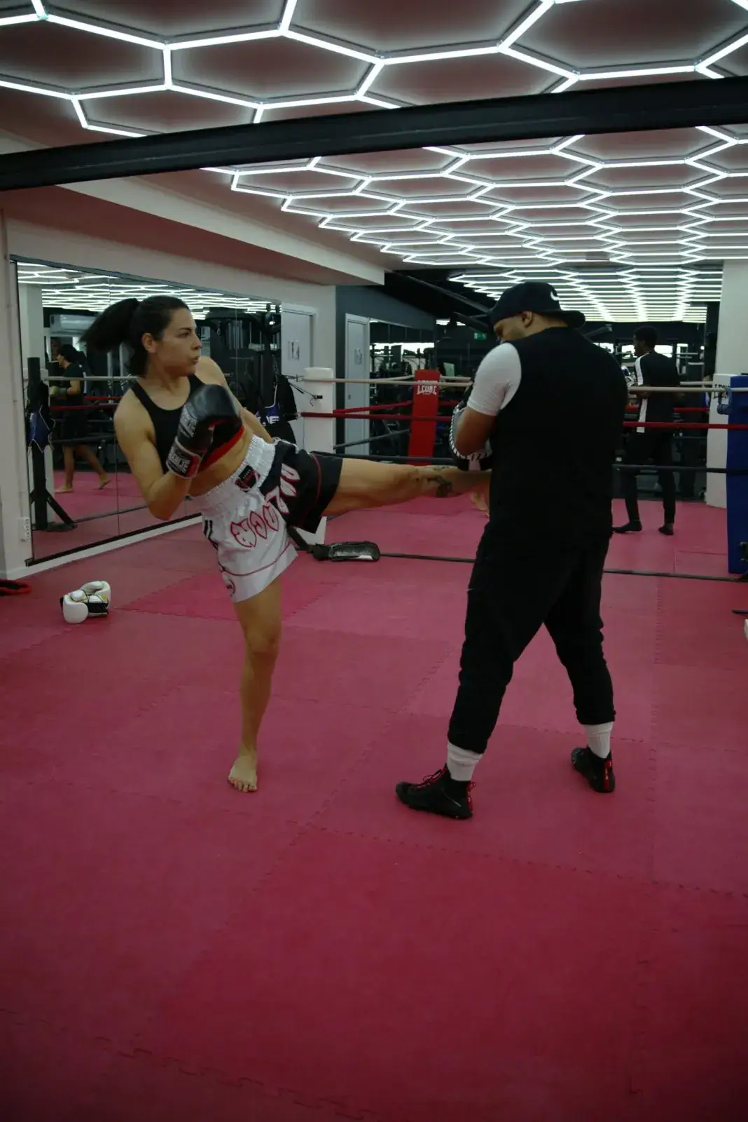 Entrenadora corrigiendo una patada al pao